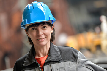 Portrait of a female worker in the industry with her protective helmet