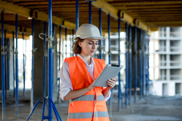 Construction concept of Engineer or Architect working at Construction Site. A woman with a tablet...