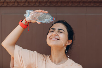 Stressed woman suffering of heatstroke and refreshing pouring with cold water outside. Weather abnormal heat concept
