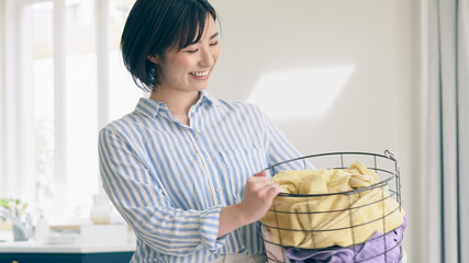 洗濯カゴを持つ笑顔の女性