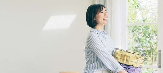 洗濯カゴを持つ笑顔の女性