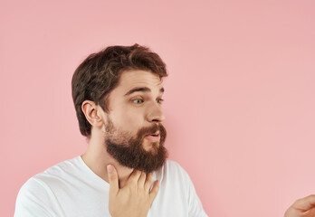 Obraz premium handsome man with beard in white t-shirt pink background emotions