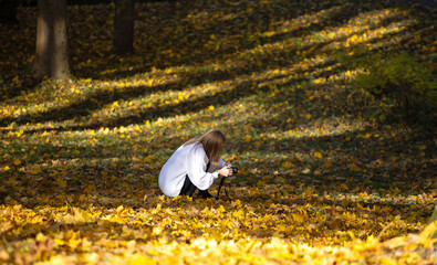 Happy lifestyle young blonde girl taking a picture with Autumn fall trees background