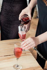 womens party. Close up woman hand pours rose wine into glasses at the celebration.