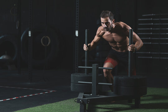 a 40-year-old man doing physical exercise in a gym.