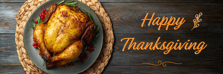 Baked chicken for festive dinner. Cooked chicken or turkey with herb rosemary and berries on wooden table. Thanksgiving holiday concept