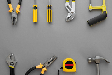 Flat lay composition with construction and home repair tools tools on grey background, space for...