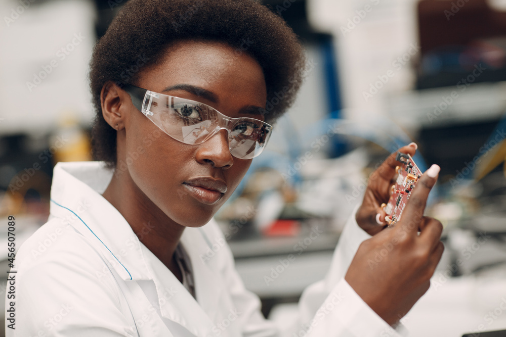 Wall mural scientist african american woman working in laboratory with electronic board. research and developme