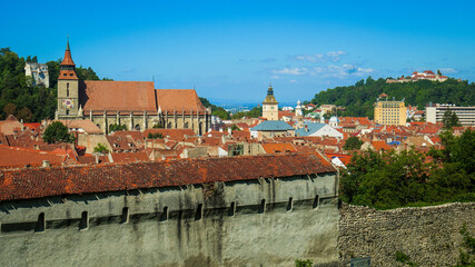 Obraz premium Overlooking the medieval city walls and red rooftops of Brasov to Black church and white towers