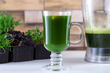 Microgreen juice on the kitchen table. Micro greens in a blender. Make a microgreen smoothie at home. Healthy and organic food