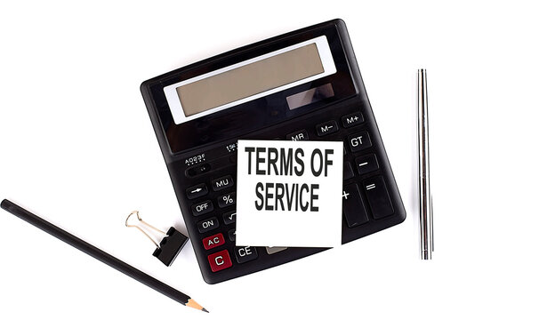 TERMS OF SERVICE text on sticker on calculator with pen,pencil on the white background