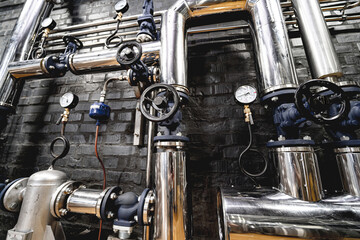 The valves and pipes at a craft modern brewery wall