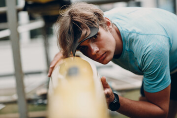Sportsman single scull man rower sportsman checking his boat. © primipil