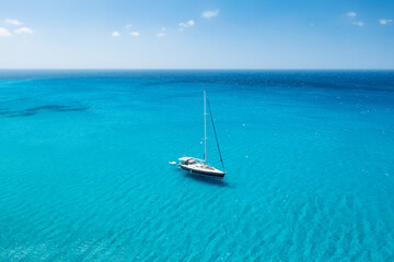 An aerial view of the yacht on the azure sea. Transparent clear water in the Mediterranean Sea....