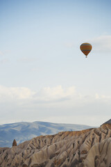 Fototapeta na wymiar Hot air balloon flying over the rocky land