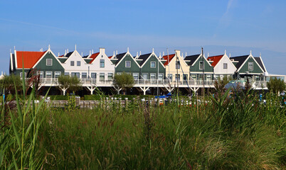 Colorful Dutch houses in a row. Classic architecture of the Netherlands. Cute countryside houses with red tiled roof. 