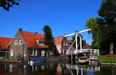 Obraz premium Beautiful Dutch city on water. Classic Dutch architecture. Sunny day city view. Authentic houses of the Netherlands. 