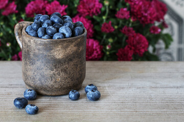 A ceramic mug full of blueberries.