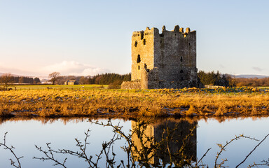 Threave Castle reflecting on the River Dee in the winter sun and ground frost
