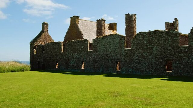 Cinematic view of the Dunnottar Castle, a medieval fortress on a rocky headland off the coast of Scotland, UK dating to 1400
