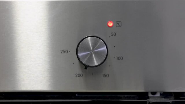 4K footage about energy consumption, video of a man's hand turning an oven thermostat to turn it on