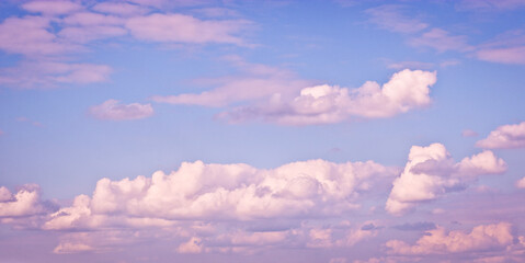 The sky with blurred cirrus and cumulus clouds illuminated by the setting sun. Natural background