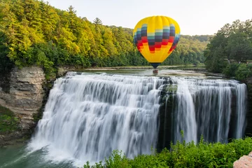  Een heteluchtballon die laag over het midden vliegt, valt in Letchworth State Park in New York. De watervallen worden getoond in lange blootstelling. © Rose Guinther