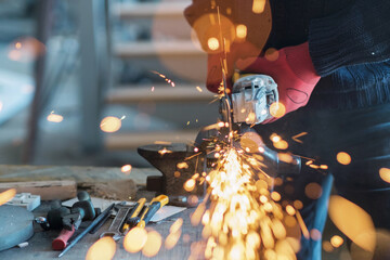 Worker working with a circular grinder on a metal with sparks flying out of them, selective focus