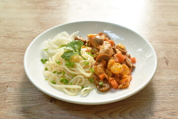 spaghetti dressing fried chop chicken and slice mushroom in ketchup sauce on plate  