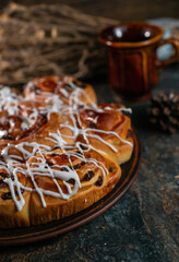 Freshly baked sweet buns on black board on grey stone background