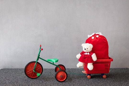 Teddy bear wearing Christmas costume sitting on vintage tricycle