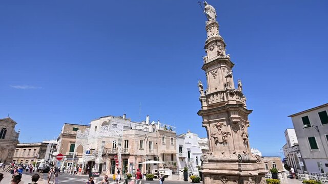 Ostuni, Puglia, Italy. August 2021. Pan footage of the Piazza Della Libert&agrave;. Highlights Column of Sant'Oronzo, 21 meters high.