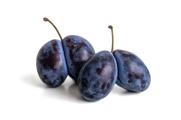 Two pairs of purple plums with a bluish bloom on a white background