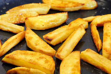Crisp and golden french fries. Home made deep fried chips. Frying potato on pan. Food cooking background. Close up view.