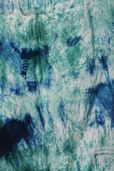 Tie dye green background with half circle layers of dye pattern fading from green to white dye fabric textile