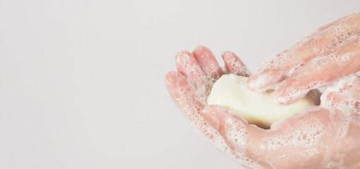 Fototapeta premium Hands washing gesture with bar soap and foam bubble on white background.