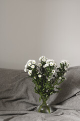 bouquet of white flowers in bed bedroom with  natural bed sheets blanket 
crumpled