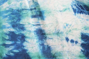 Tie dye green background with half circle layers of dye pattern fading from green to white dye fabric textile