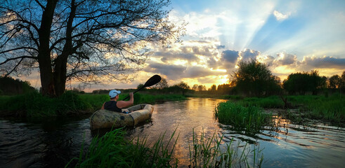 Packraft o zachodzie słońca nad rzeką Swędrnią koło Kalisza. - obrazy, fototapety, plakaty
