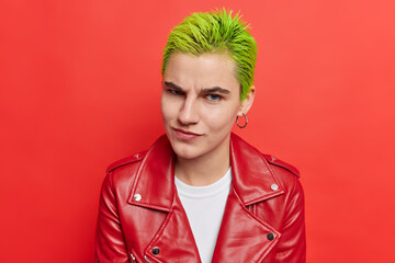 Photo of hipster girl with trendy green hairstyle belongs to youth subculture has unique style....