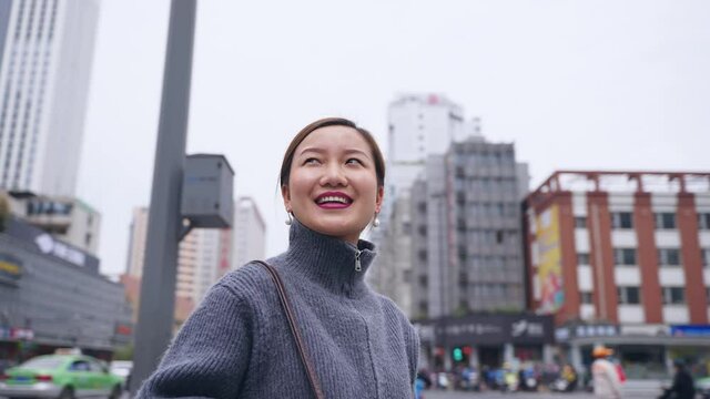 slow motion 4k clip of happy asian woman looking around in the urban city street with Moving Around 360 Camera