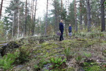 Mother and son pick mushrooms in forest