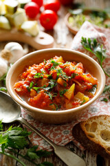 Vegetable zucchini and pumpkin stew sprinkled with fresh parsley in a ceramic bowl, close up