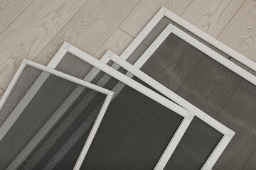 Set of window screens on wooden floor, closeup