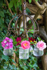 pink Blumen in Glasvasen hängend am Kräutertrockner als Dekoration