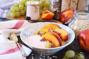 Healthy summer breakfast. Oatmeal, fruit yogurt, peaches and grapes