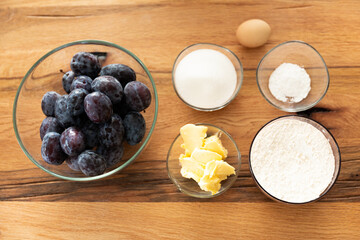 Home cooking baking plum cake with ingredients on wooden table, top view