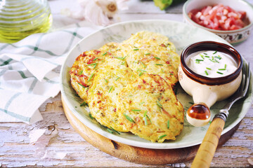 Zucchini fritters. Squash pancakes with bacon and sour cream