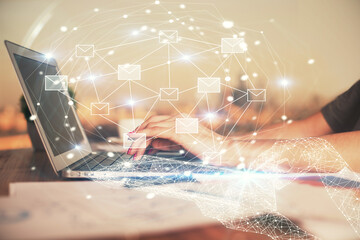 Double exposure of woman hands typing on computer and flying envelop drawing. E-Mail concept.