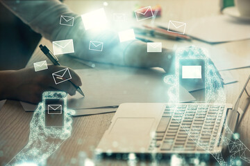 Double exposure of woman hands typing on computer and flying envelop drawing. E-Mail concept.